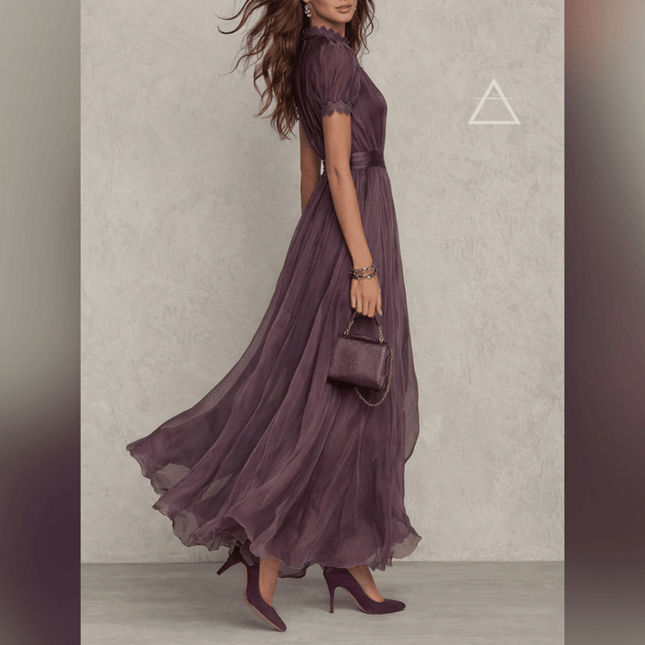 Robe Isaline en violet profond portée de profil, avec manches courtes bouffantes.