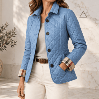 Veste matelassée Margaux en bleu clair, portée de face avec un pantalon écru et les poignets retournés laissant apparaître les revers à carreaux.