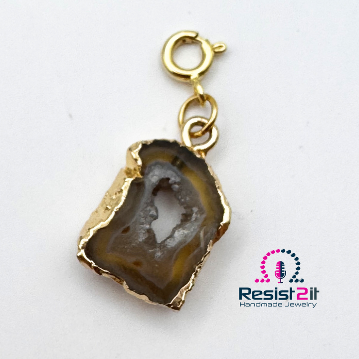 Gros plan du pendentif en agate d’Unspoken, montrant ses contours irréguliers et son centre cristallin.